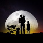 Une famille marche vers la lune avec leur chien.